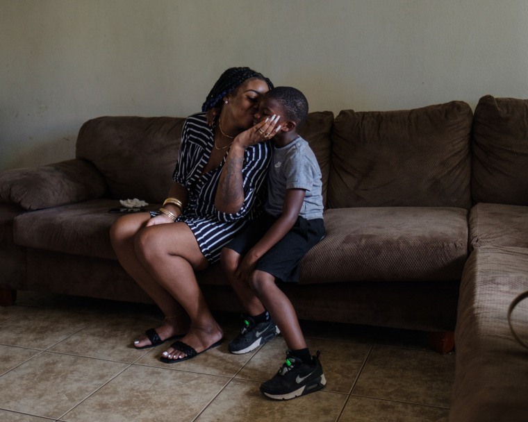 Smith kisses her son in their living room. 
