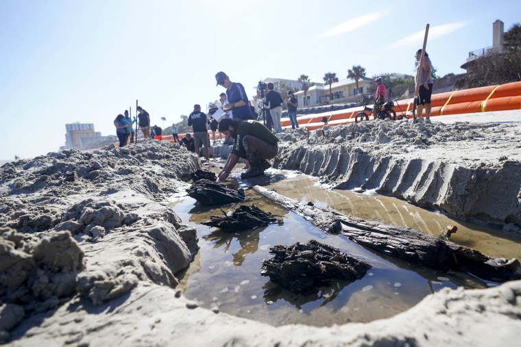 Severe beach erosion caused by two late-season hurricanes helped partially uncover what appears to be part of an 80-foot-long (24-meters) ship in the sand on Daytona Beach Shores, officials said. (AP Photo/John Raoux)