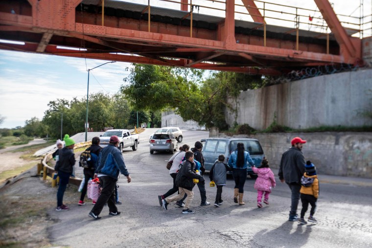 A group of migrants cross the street