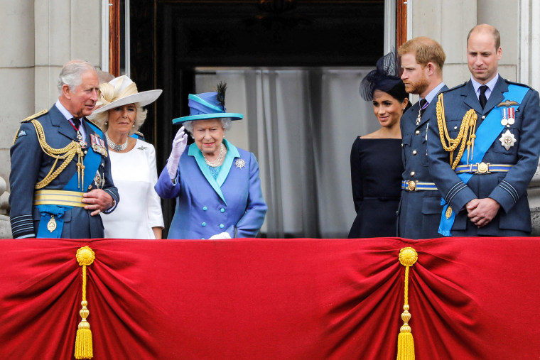 Image: Prince Charles, Prince of Wales, Camilla, Duchess of Cornwall, Queen Elizabeth II, Meghan, Duchess of Sussex, Prince Harry, Duke of Sussex and Prince William, Duke of Cambridge stand on the balcony of Buckingham Palace to watch a military fly-past to mark the centenary of the Royal Air Force (RAF) on July 10, 2018.