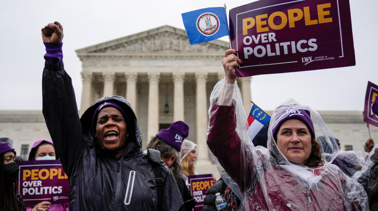 Image: Members of the League of Women voters rally for voting rights outside the Supreme Court with signs that read,"People over Politics".