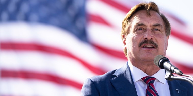 Image: Mike Lindell speaking with the American behind him.