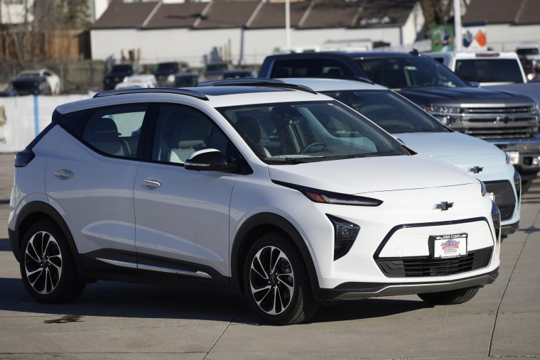 Bolt electric vehicles sit in an empty storage lot at a Chevrolet dealership in Englewood, Colo.