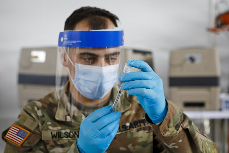 A U.S. Army soldier prepares a dose of the Pfizer-BioNTech Covid-19 vaccines at Miami Dade College North Campus in North Miami, Fla., on March 10, 2021. 