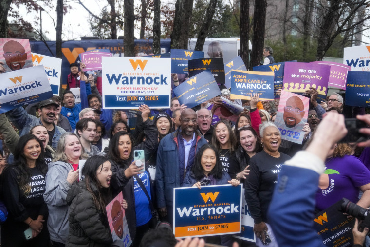 Sen. Raphael Warnock poses with supporters on election day in Norcross, Ga. 