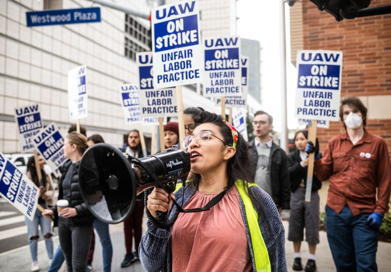 Gloria Bartolo, a 2nd year molecular biology PhD student, leads marching UCLA postdoctoral scholars and academic researchers in Westwood as they demand better wages, student housing, child care and more with University of California on Dec. 1, 2022.