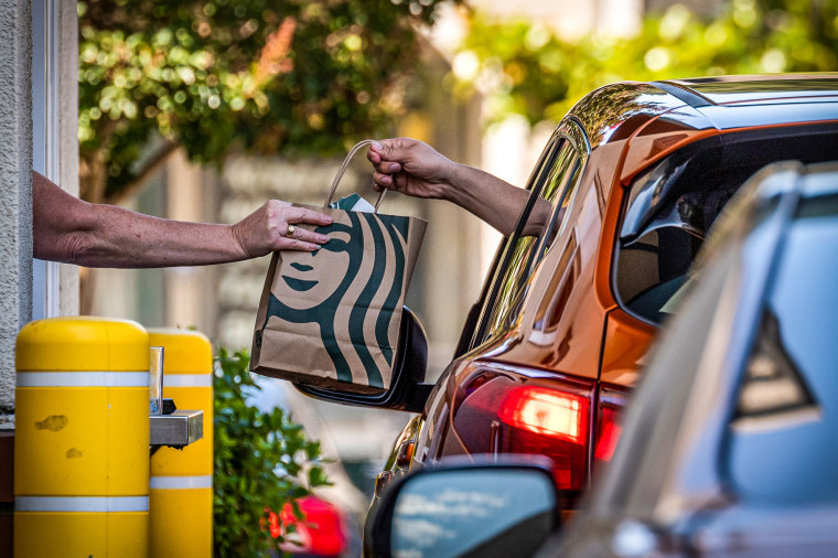 An employee hands a bag to a customer at the drive-thru of a Starbucks coffee shop in Hercules, Calif., on July 28, 2022.