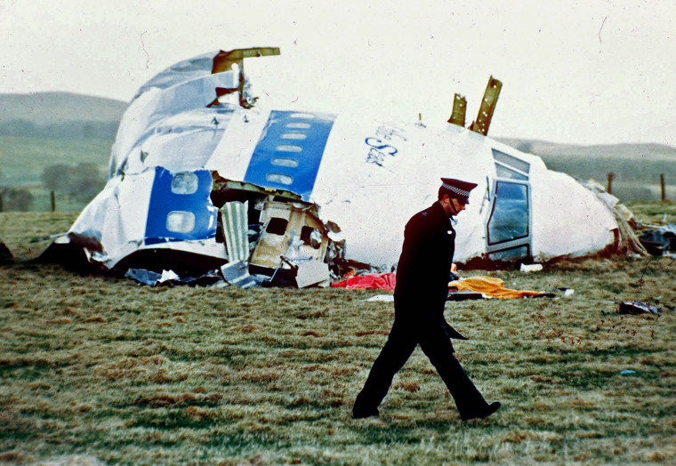 A police officer walks by the nose of Pan Am flight 103 in a field near the town of Lockerbie, Scotland
