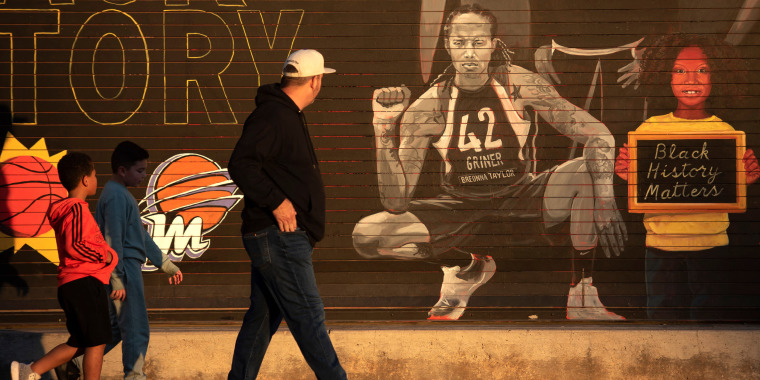 Image: People walk by a mural of Brittney Griner outside of the Footprint Center in Phoenix, Arizona.
