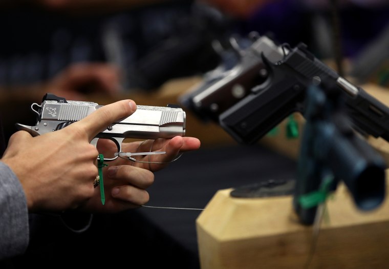 An attendee inspects a handgun during the NRA Annual Meeting & Exhibits in Dallas