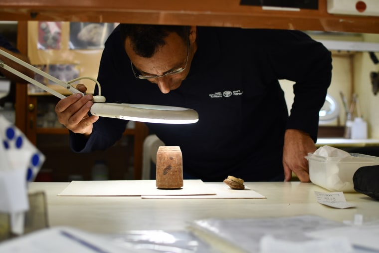Amir Ganor, head of the Murba'at excavations team, inspects the coins in an ancient wooden box. 