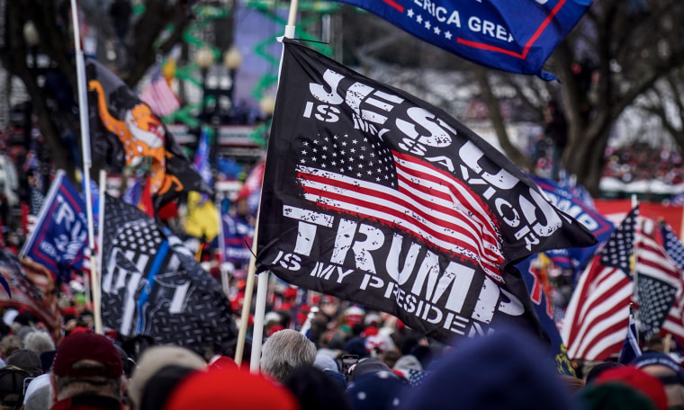 Image: A flag at a protest rally reads,"Jesus is my savior, Trump is my president".