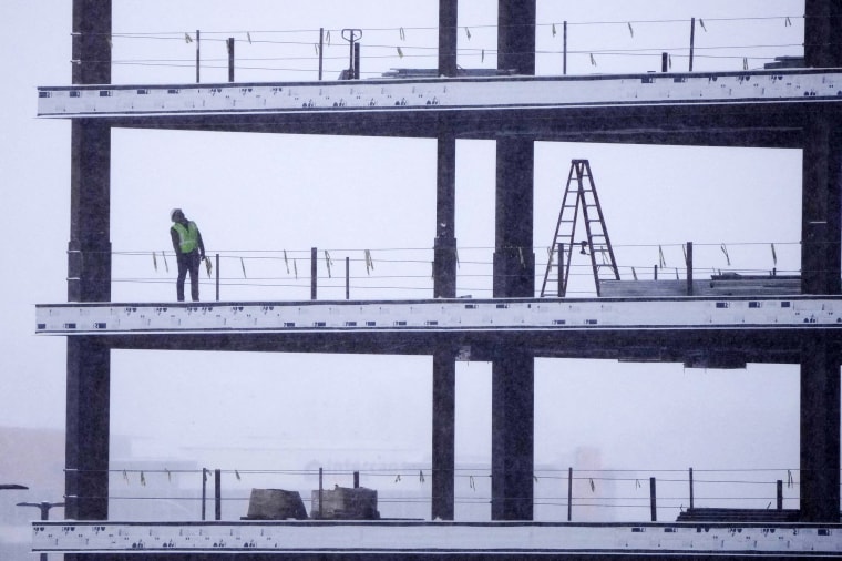 A man works on a building in a snow storm in Lehi, Utah, on Dec. 13, 2022.