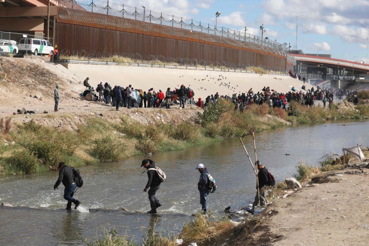 Migrants walk across the Rio Grande to surrender to US Border Patrol agents