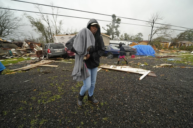 Chelsi Bovie holds her niece's dog that she rescued from her home after a tornado tore through the area in Killona, La., on Dec. 14, 2022. 