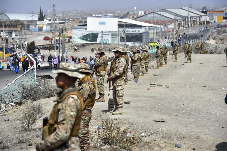 Soldiers stand guard after clearing a roadblock to the airport in Arequipa, Peru