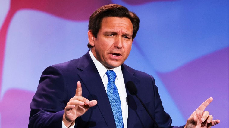 Image: Florida Governor Ron DeSantis gestures while speaking on stage.