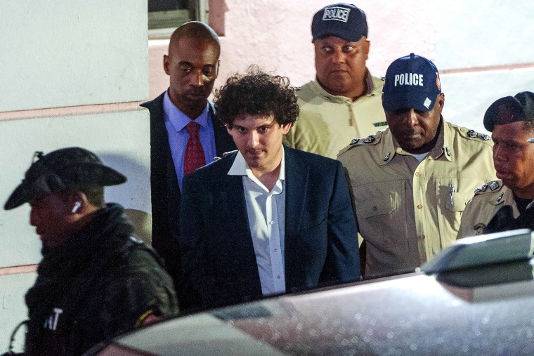 FTX founder Sam Bankman-Fried is led away in handcuffs by officers of the Royal Bahamas Police Force in Nassau on Dec.13, 2022.