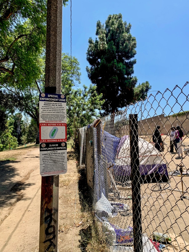 Un cartel de no acampar junto a un campamento para personas sin hogar en Hollenbeck Park.