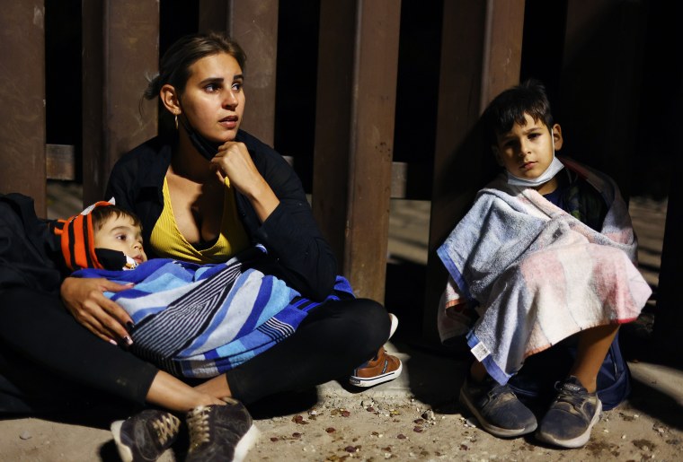 An immigrant mother from Cuba sits with her sons after crossing the border from Mexico in Yuma, Ariz. 