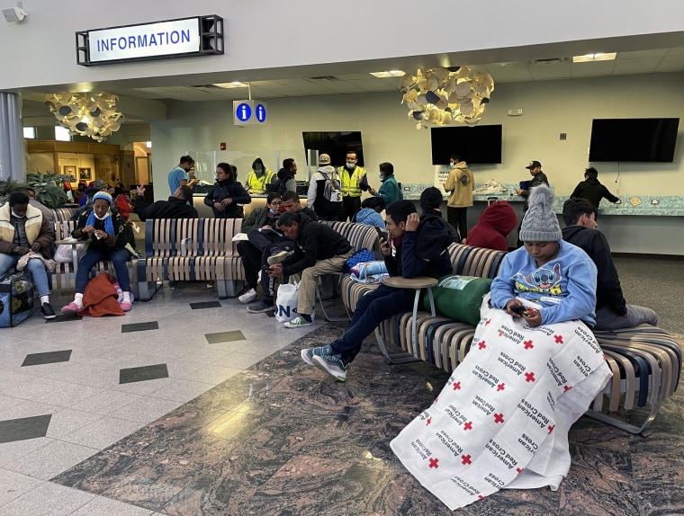 Migrants who have crossed the border and have been released by Border Patrol wait at the airport in El Paso, Texas