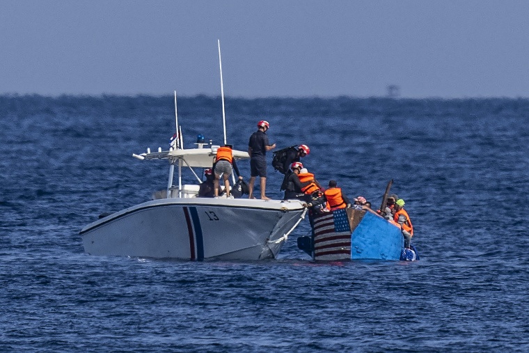 People in a makeshift boat with the U.S. flag painted on the side are captured by the Cuban Coast Guard near the Malecon seawall in Havana, Cuba, on Dec. 12, 2022.