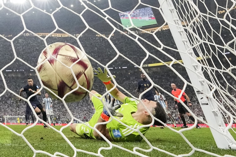 France's Kylian Mbappe scores his side's first goal from the penalty spot past Argentina's goalkeeper Emiliano Martinez during the World Cup final soccer match between Argentina and France in Lusail, Qatar, on Dec. 18, 2022.