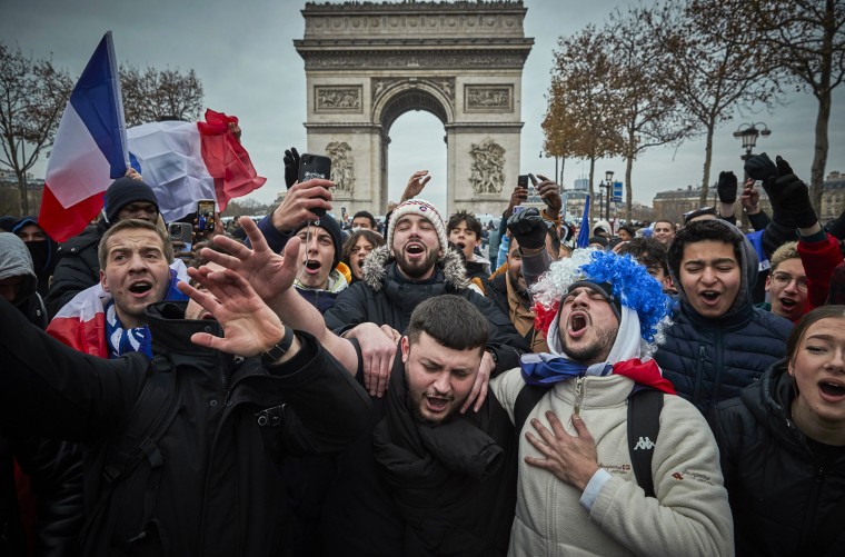 French football fans sing the French National Anthem on the Champs Elysees in Paris as fans gather to watch France play Argentina in the World Cup final on Dec. 18, 2022.