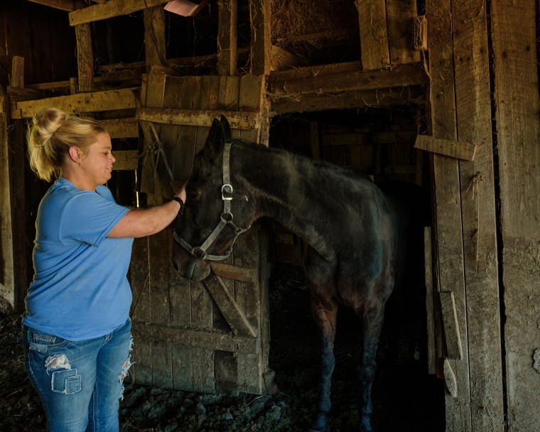 Snodgrass petting a black horse.