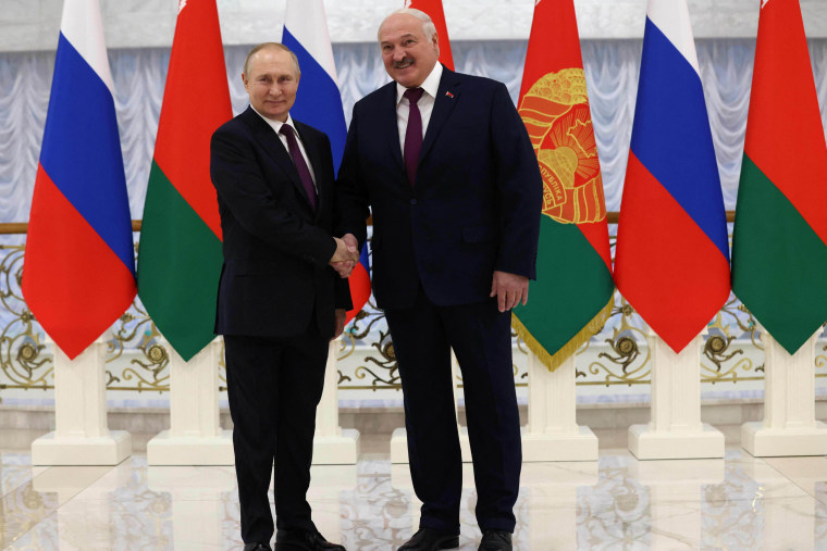 Putin and Lukashenko shake hands before their meeting at the Palace of Independence in Minsk on December 19, 2022.