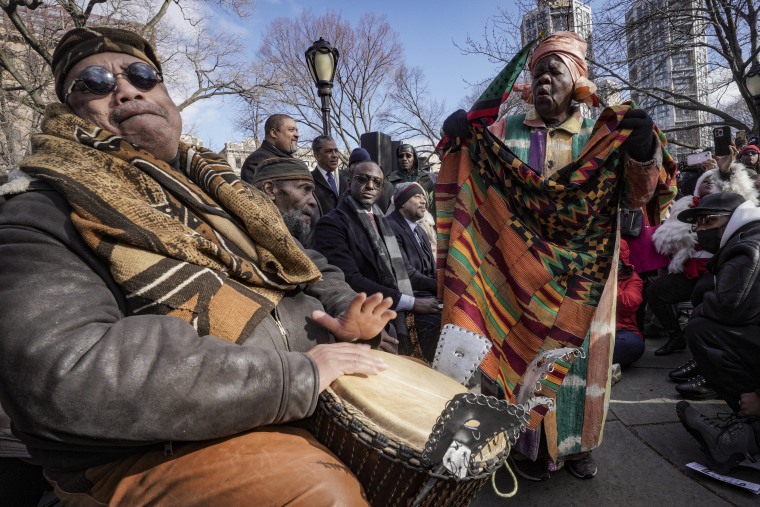 Master drummer Baba Don Babatunde, left, and civil rights activist Queen Mother Moore, right, lead a spiritual moment at the Central Park gate-naming ceremony Monday in New York. 