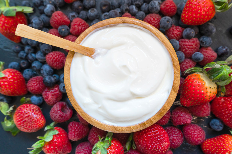 Greek yogurt in a glass jars with spoons,Healthy breakfast with Fresh greek yogurt, muesli and berries on background