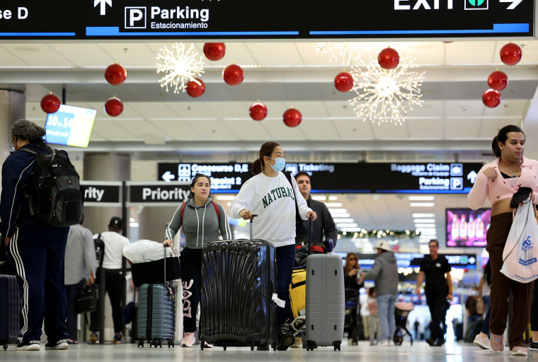 Travelers walk through Miami International Airport in Miami 