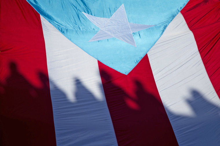 Demonstrators carry a Puerto Rican flag at a "United for Health" march to protest cuts to Medicare and Medicaid funding for the island in 2015. 