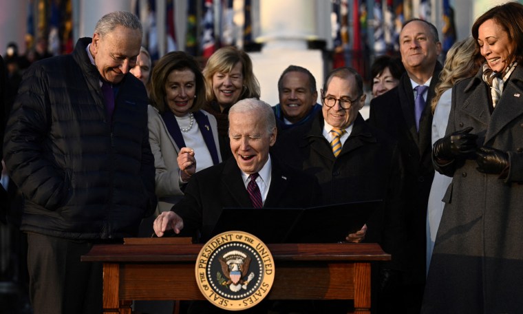 Image: Surrounded by Chuck Schumer, Nancy Pelosi and Kamala Harris amongst others, President Joe Biden signs the Respect for Marriage Act on the South Lawn of the White House