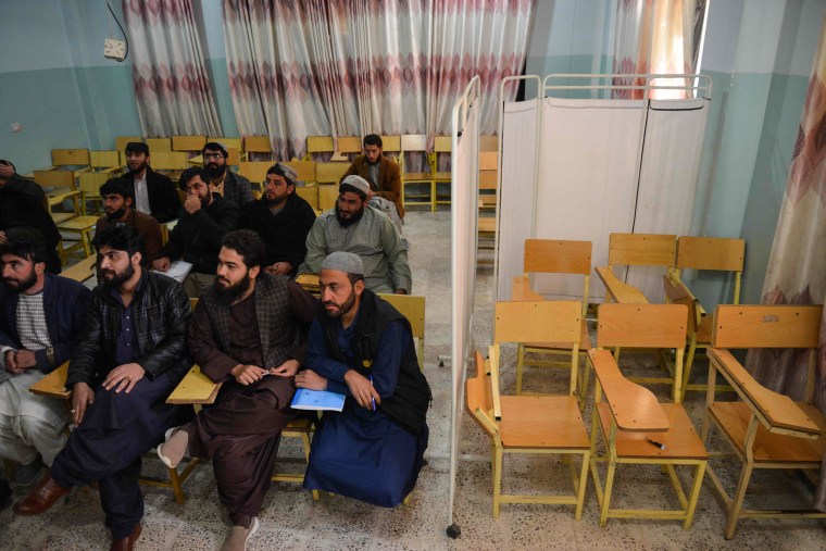 Men attend university in a classroom with a curtain separating men and women in Kandahar Province on Dec. 21, 2022.