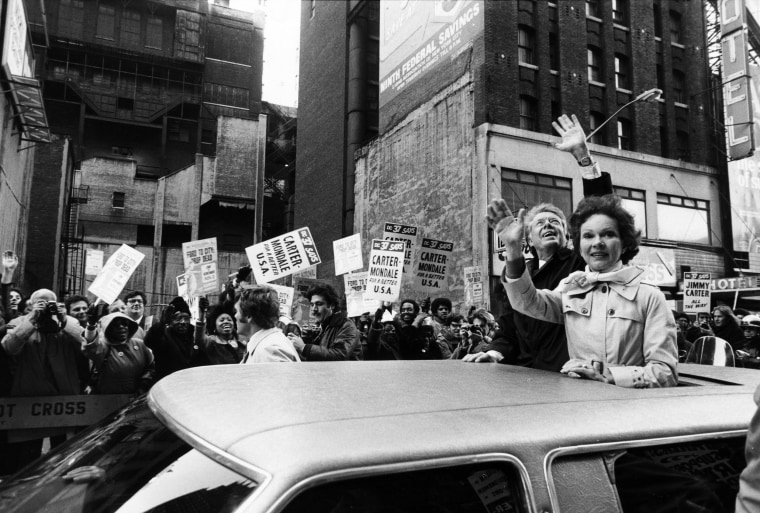 Presidential candidate Jimmy Carter waves from the sun roof of a car with his wife Rosalynn in New York City.