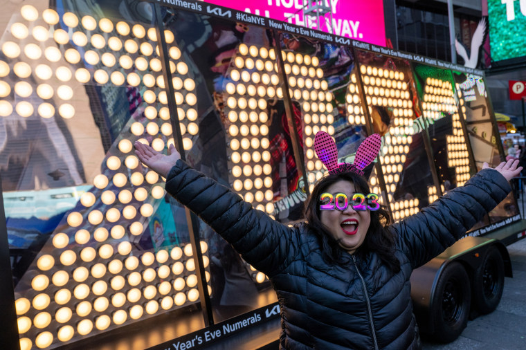 Teresa Hui, wearing 2023 glasses, poses in front of the “2023” numerals after the illumination ceremony in Times Square 