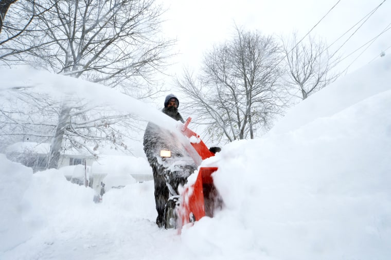 A man uses a snowblower following a snowstorm