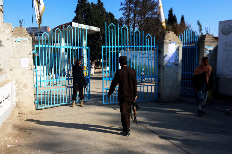 Taliban fighters stand guard at the entrance gate of a university in Jalalabad on December 21, 2022.