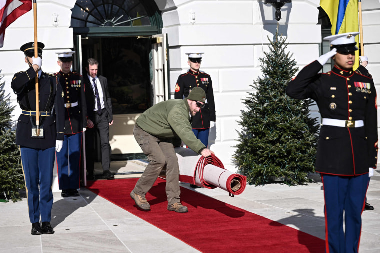 A Park Service worker carries a red carpet ahead of President Joe Biden's welcoming Ukraine's President Volodymyr Zelensky on the South Lawn of the White House on Dec. 21, 2022.