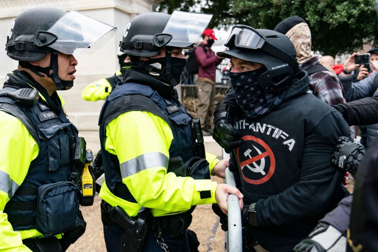 A protester, who claims to be a member of the Proud Boys, confronts police officers outside the Capitol