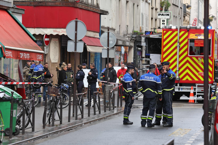 Security personnel secure the street after several shots were fired along rue d'Enghien in Paris on Dec. 23, 2022. 