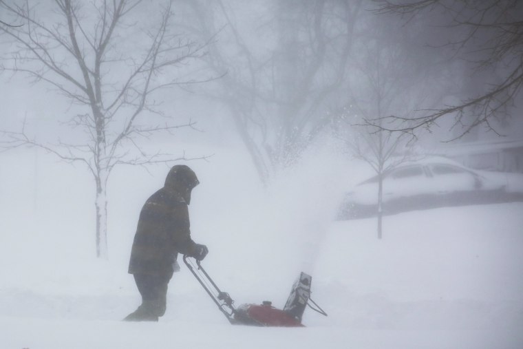 A person clears snow in Amherst N.Y. as a winter storm rolls through Western New York on Saturday, Dec. 24, 2022.