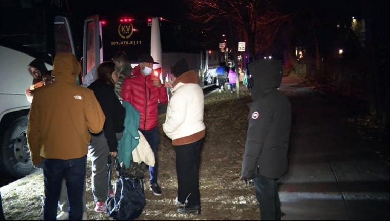 Migrant families get on a bus to be transported to a church after they arrived in Washington, on Dec. 24, 2022.