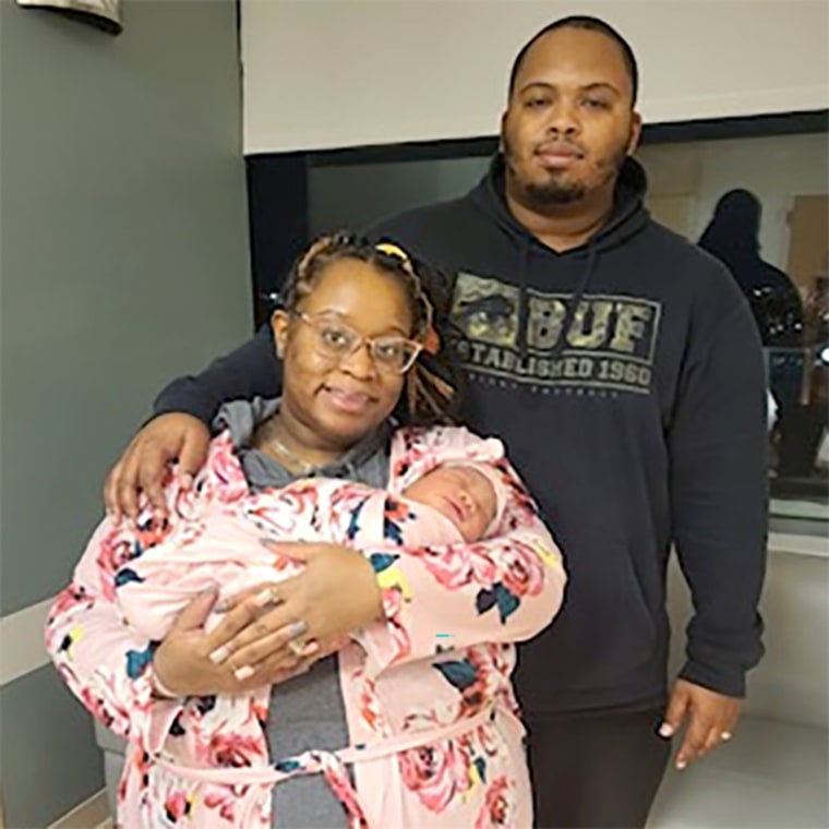 Davon Thomas stands with his wife, Erica Thomas, who is holding their newborn child, Devynn Brielle Thomas.