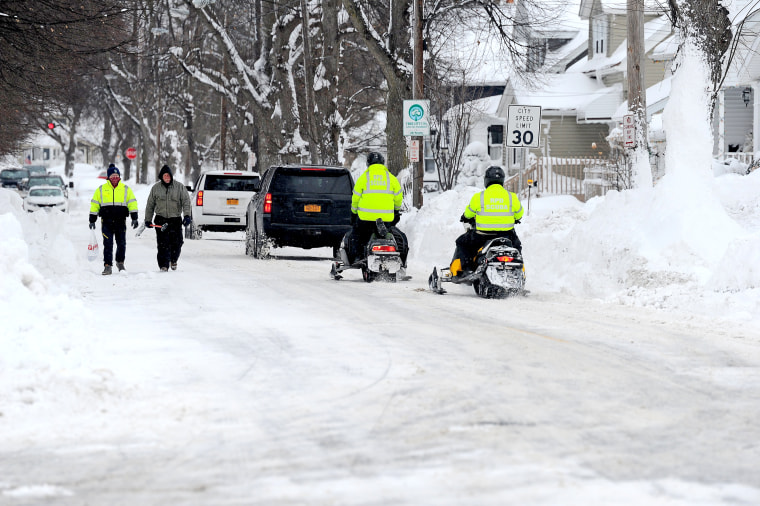 Image: First responders check on abandoned vehicles along a road on Dec. 26, 2022 in Buffalo, N.Y.