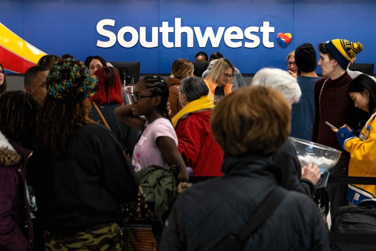 Travellers wait in line at the Southwest Airlines ticketing counter at Nashville International Airport after the airline cancelled thousands of flights in Nashville, Tennessee, on December 27, 2022. - Temperatures were expected to moderate across the eastern and midwest US on December 27, after days of freezing weather from "the blizzard of the century" left at least 49 dead and caused Christmas travel chaos.