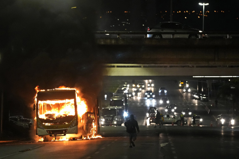 Supporters of Brazilian President Jair Bolsonaro clash with police setting fire to several vehicles in Brasilia on Dec. 12, 2022.
