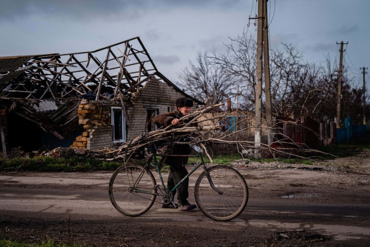 Locals collect wood during as fighting with Russian forces intensifies near Kherson. 